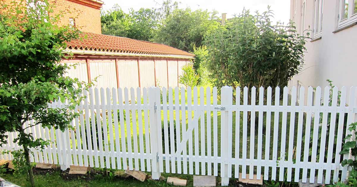 Nyt hvidt hegn i træ i en have opsat af tømrerfirma Martin Friis